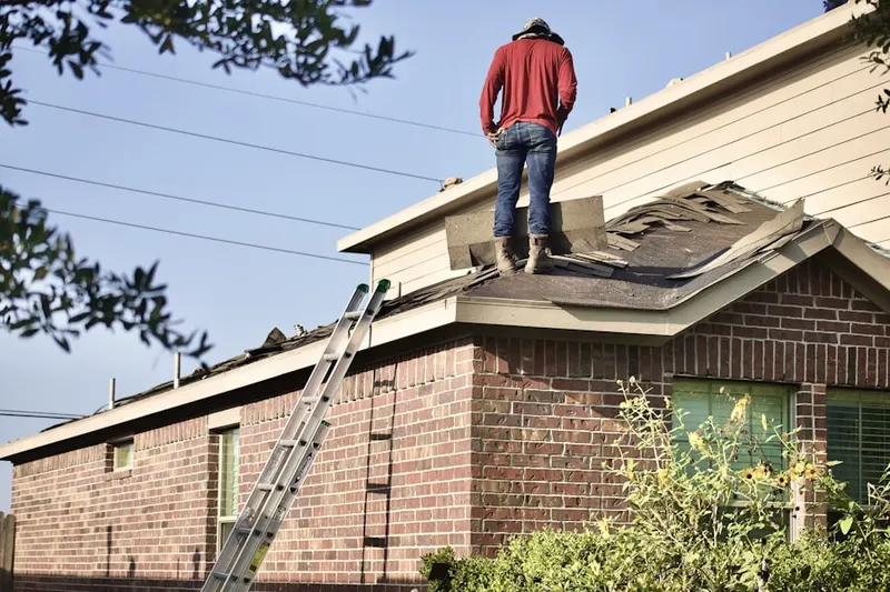Professional roofer working on a residential roof in Prides Crossing